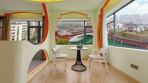 Una habitación con vista a un puente, una mesa con sillas y una ventana con cortinas.