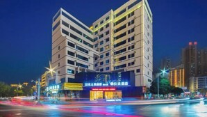 A multi-story hotel with a modern design, featuring a prominent entrance and signage. - Tongren Grand Hotel (Tongren High-speed Railway Station Ancient City Pedestrian Street Branch) (Tongren)