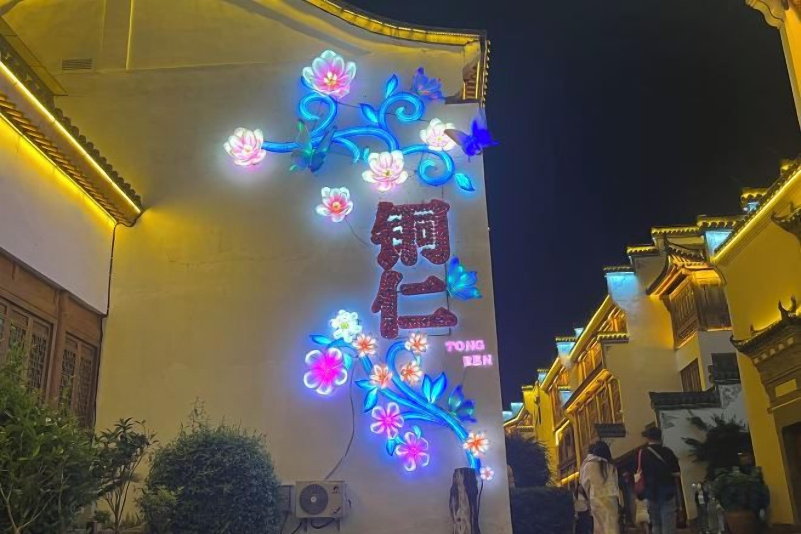Fachada de edificio con señalización iluminada y elementos arquitectónicos tradicionales.