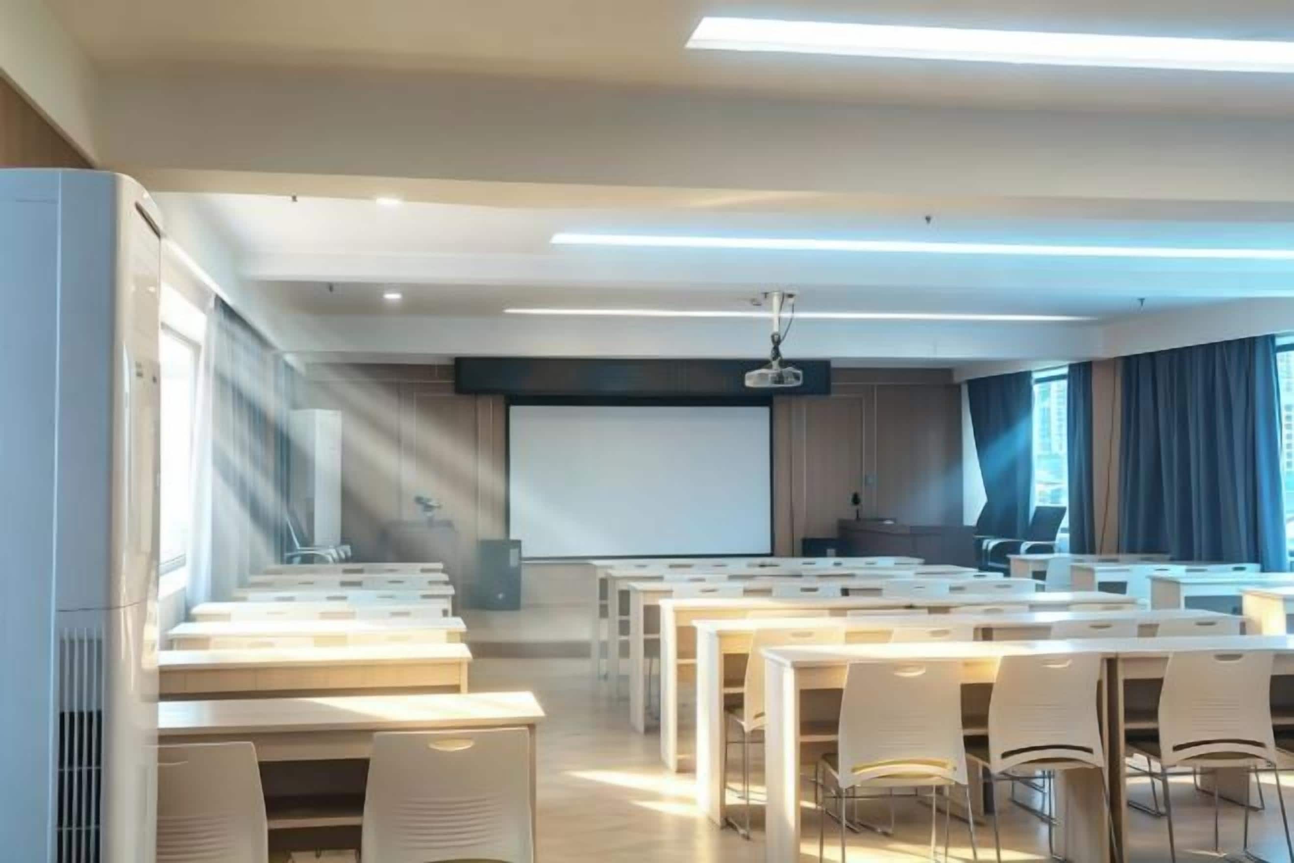 A conference room with multiple tables and chairs, a projector screen, and a large window with curtains.