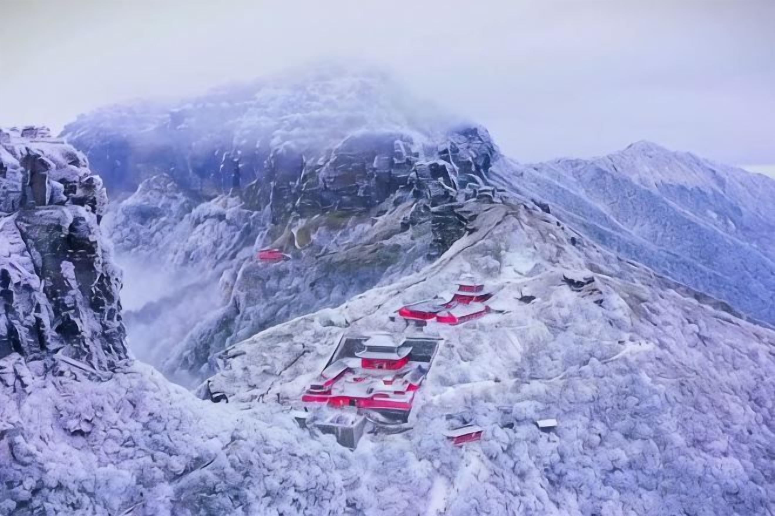 A snow-covered mountain with a red-roofed building complex.