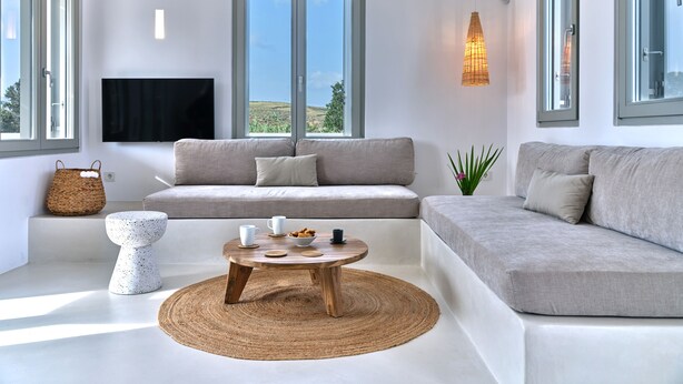 A modern living room with a sofa, a coffee table, and a TV. - Perivoli Luxury Homes, Paros, Greece (Paros)