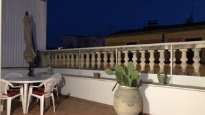A terrace with a table and chairs, a potted plant, and a railing. - Casa Negli Iblei - South East Sicily (Canicattini Bagni)