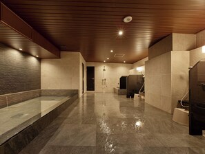 Relax in a serene space with a shower area and bench, perfect for unwinding.