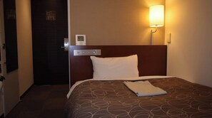 Cozy retreat with a neatly made bed and a bedside table.