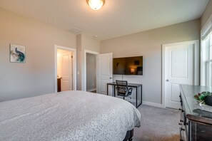 A bedroom with a large bed, a desk with a chair, a television, and a dresser. - Lovely Bowling Green Home, 10 Mi to Downtown! (Bowling Green)