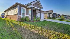 A modern single-story house with a front porch, a garage, and a well-maintained lawn.