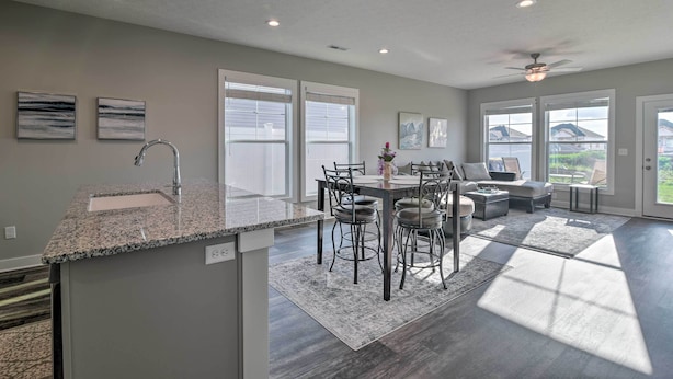 A spacious kitchen with granite countertops and a dining area with a table and chairs.