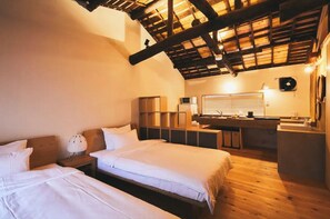 Cozy bedroom with two single beds, a kitchenette, and storage.