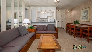 Una sala moderna con sofá, mesa de centro y comedor con muebles de madera.