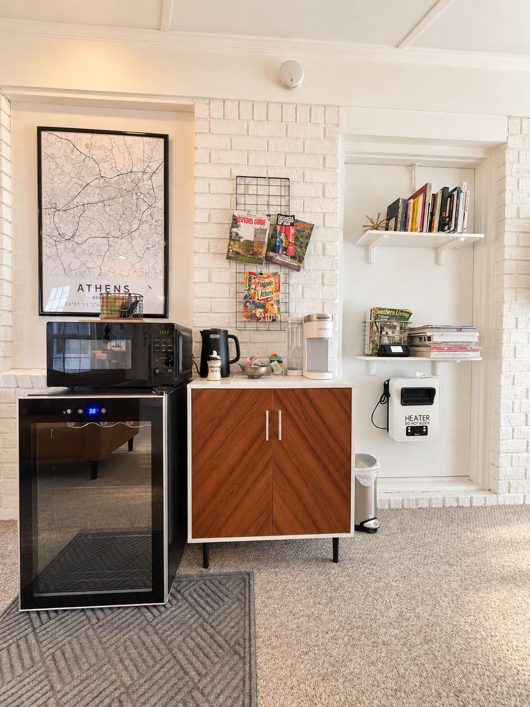 Una cocina con microondas, cafetera y un armario con reloj digital.