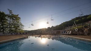 Ein Schwimmbecken mit Liegestühlen und einer Steinmauer.