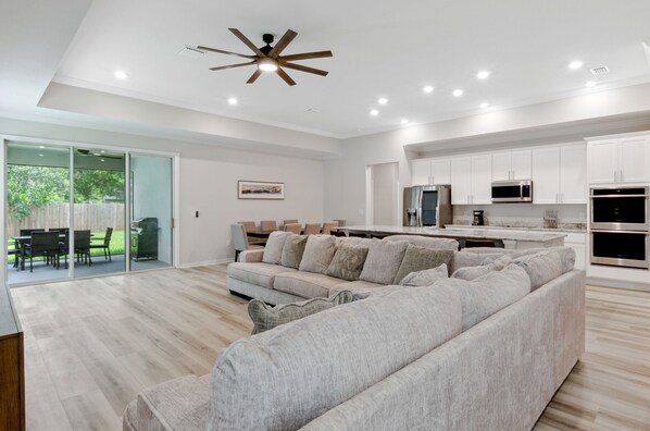 A modern kitchen with white cabinets, a built-in microwave, and a double oven.