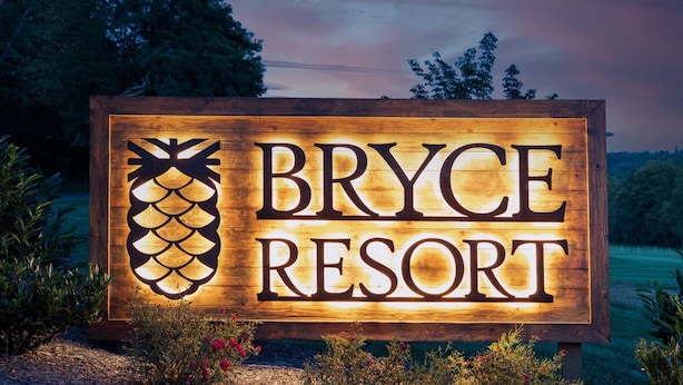 Ein Holzschild für Bryce Resort mit einem Ananas-Design.