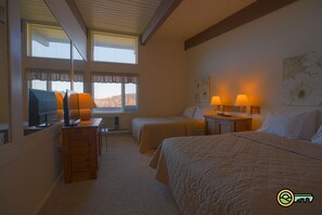 Two single beds and a larger bed feature matching headboards in this inviting room.