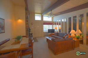 Cozy living area with a high ceiling, comfortable seating, and a fireplace.