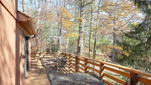 Un patio al aire libre con barandas de madera, mesas y sillas de metal.