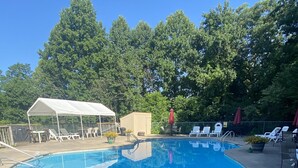 A swimming pool with a white canopy and lounge chairs. - Cozy Mountain Chalet (#102) - Quiet location | Summertime secluded | Great winter views! (Basye)