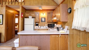 A kitchen with wooden cabinets, a white countertop, and a built-in microwave. - Mountainside Chalet (#141A) - Close to Resort lodge | Great view of valley & golf course! (Basye)