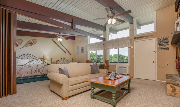 A cozy living room with a beige sofa, a wooden coffee table, and a ceiling fan.