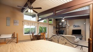 A bedroom with a bed, a dining table with chairs, a fireplace, and a television. - Logan Lodge (Unit #135) | Ski/MTB/Golf | Ski slope & Resort valley views | Vaulted ceilings! (Basye)