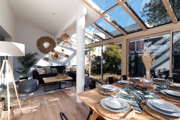 A modern living room with a sofa, coffee table, and a dining area set for a meal.
