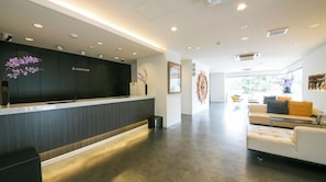 Welcome to our reception area, featuring a sleek reception desk and comfortable seating area with a sofa and coffee table.
