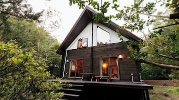 Relax on the spacious deck with outdoor seating, surrounded by lush greenery.