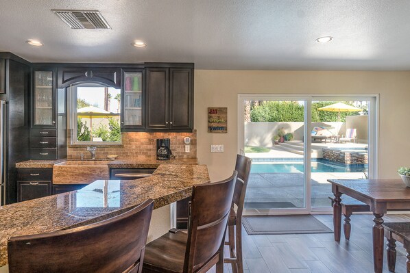 Enjoy dining and socializing in this stylish kitchen with island and sliding glass door to a serene patio area.