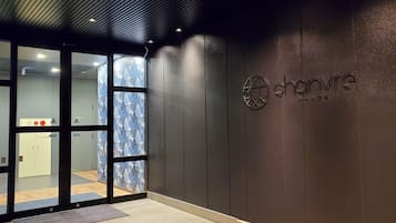 A modern interior with a glass door entrance, a wall-mounted sign reading "chainvire," and a private room sign.