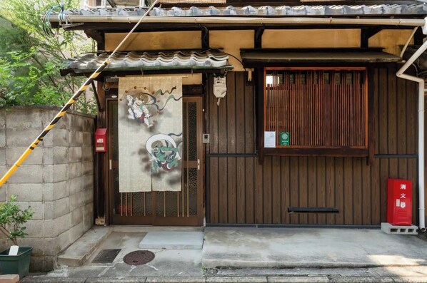 Una puerta tradicional japonesa de madera con un adorno colgante.