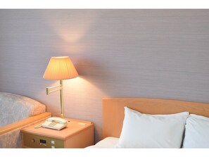 Restful retreat with a neatly made bed, bedside table, and lamp.