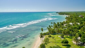 Une vue sur la côte, avec une eau turquoise cristalline, une plage de sable et une végétation luxuriante.