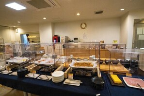 A buffet setup with various food items and utensils, a clock on the wall, and a clear glass partition. - Semidouble room Smoking allowed Narrow double / Handa Aichi (Handa)