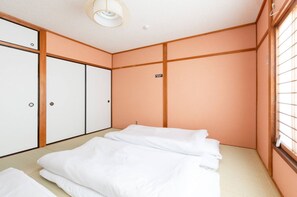Habitación de hotel con cama, armario y ventana con persianas.