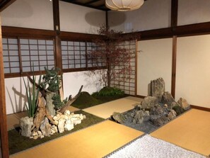 Experience serene tranquility in this traditional Japanese-inspired space with tatami flooring, shoji screen, and natural elements.