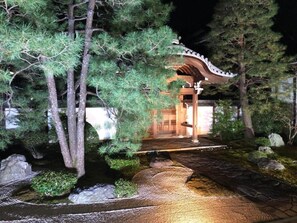 Stroll through a serene Japanese garden, surrounded by lush greenery and a traditional torii gate.