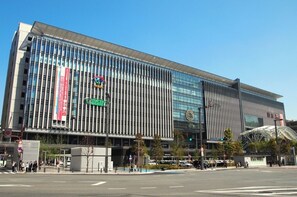 Un edificio moderno con fachada de vidrio, varios pisos y un área de entrada destacada.