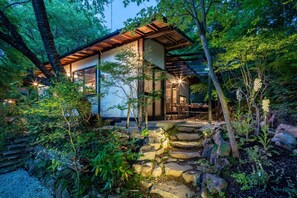 Ein modernes Haus mit einer Holterrasse und Steinstufen, die zum Eingang führen.