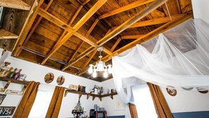 A rustic interior with exposed wooden beams, a chandelier, and vintage decor. - Restored 1930’s Tiny Home 3 min to Cape Charles (Cape Charles)