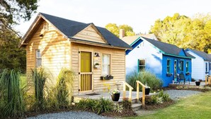 A row of wooden cabins with a gravel driveway and a grassy area in front. - Restored 1930’s Tiny Home 3 min to Cape Charles (Cape Charles)