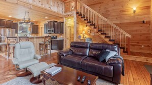 Ein Holzblockhaus mit Wohnzimmer, Küche und einer Treppe.