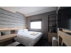 Relax in a cozy space with a made bed, desk, and flat-screen TV.