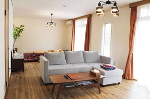 Relax in this inviting living space with a comfortable sofa, dining area, and large window.