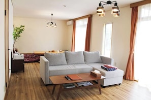 Relax in this inviting living space with a comfortable sofa, dining area, and large window.