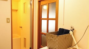 A bathroom with a wooden door, a window, and a towel rack.