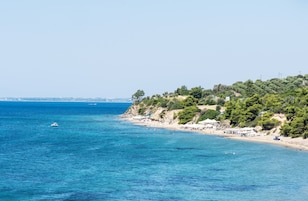 Una playa cerca, sillas reclinables de playa, sombrillas