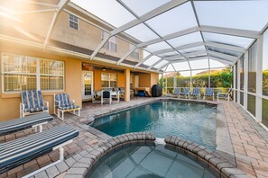 A covered swimming pool with lounge chairs and a hot tub. - Amazing 5Bed,7 Bath Pool/HotTub,Games Near Disney! (Davenport)