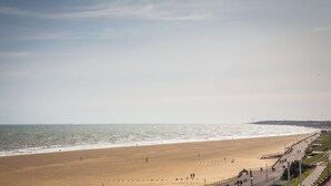 Une vaste plage de sable bordée d’une promenade en bord de mer.