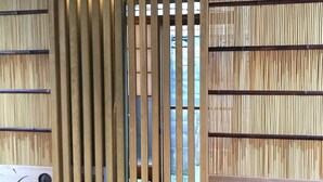 Una reja de madera con listones verticales y una ventana en el centro.